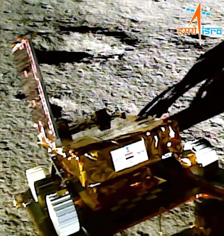 Chandrayaan-3 – Pragyan rover rolling out of Vikram lander via ramp with Indian emblem and flag.webp